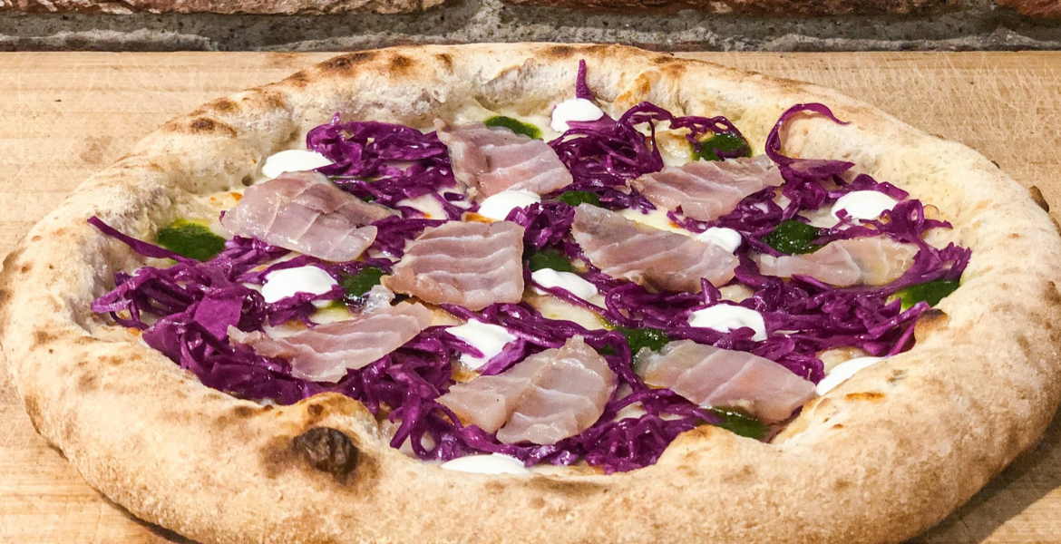 Pizza with purple cabbage, sour cream, green sauce and smoked sturgeon 